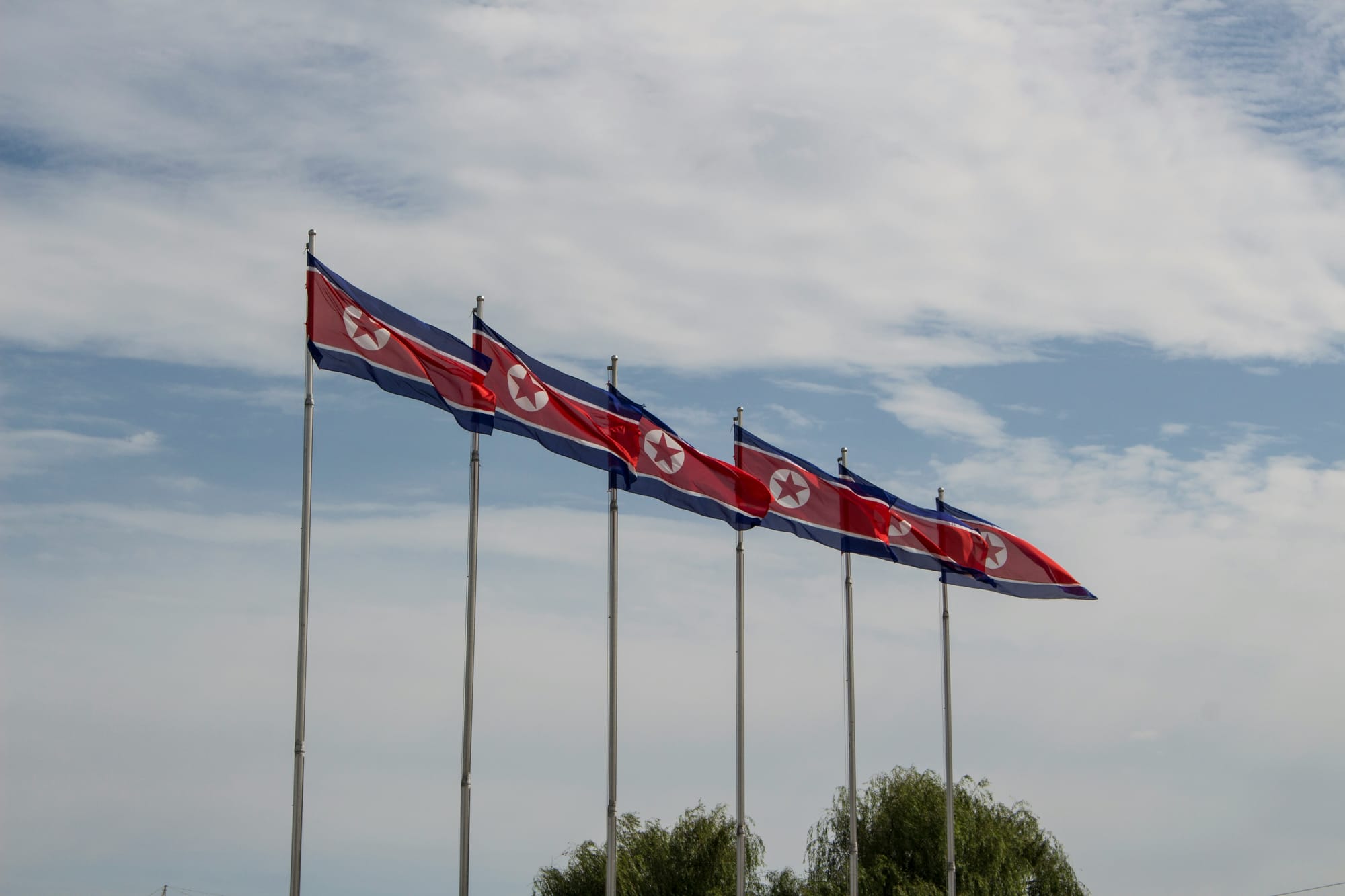 하늘을 배경으로 북한 국기 여섯 개가 나란히 걸려 있다.